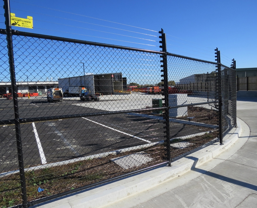 Image showing a Fencerite chainlink fence bordering an industrial carpark with building in the background