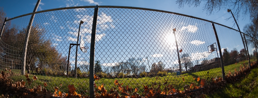 Image showing a sports field with blue sky up above, looking through chainlink fencing