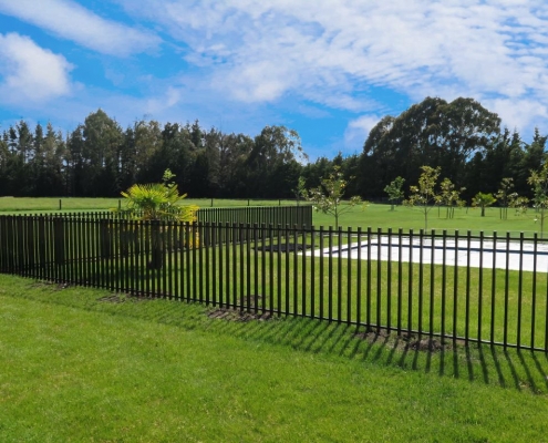 Image showing pool fencing surrounding a pool with beautiful green grass in a park-like setting