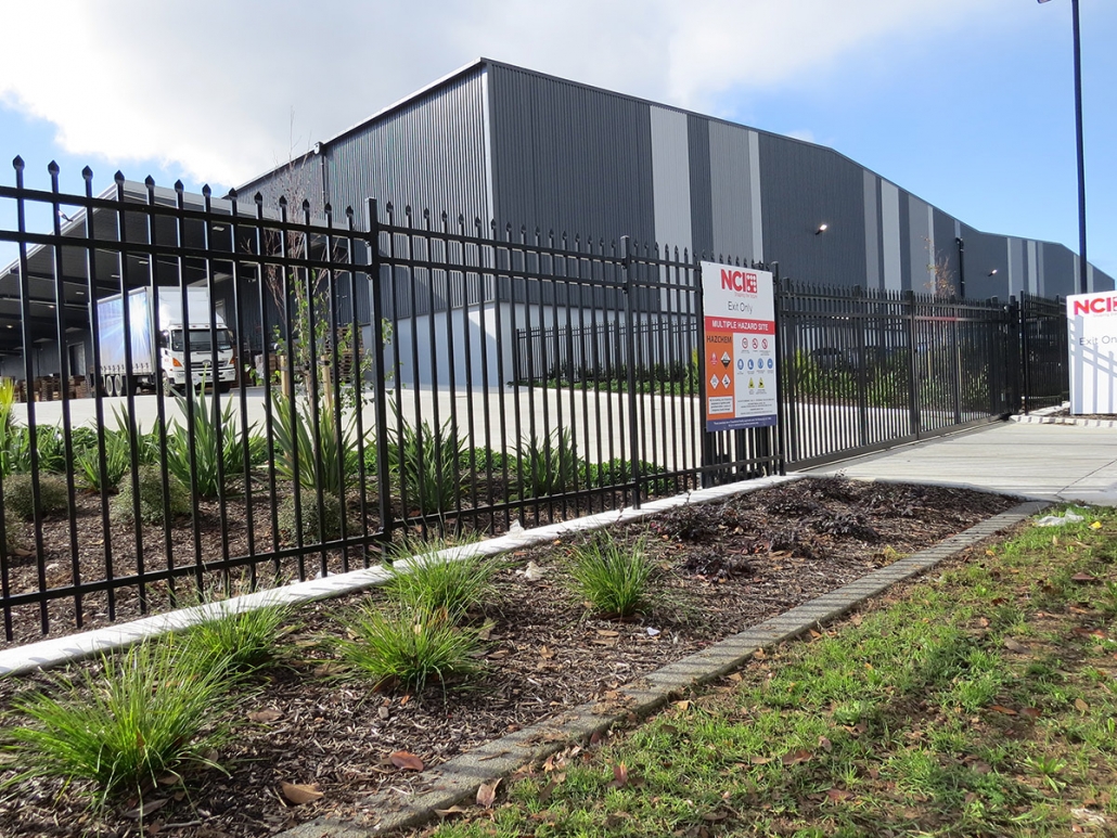 Image showing a black aluminium security sliding gate, in front of the NCI Packaging building in Auckland, installed by Fencerite
