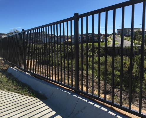 Image showing black balustrades, bordering a gully and residential area in the background, installed by Fencerite