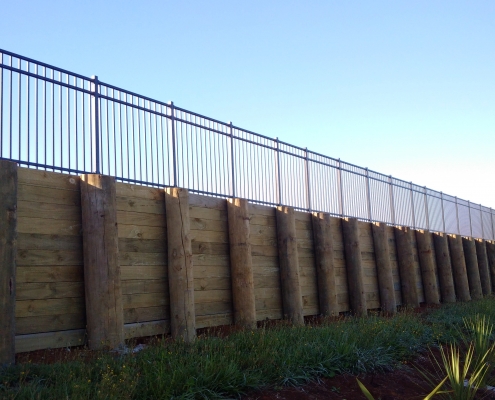 Image showing a retaining wall with black balustrades at the top, installed by Fencerite