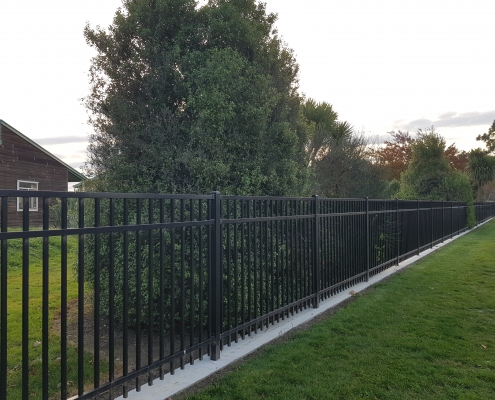 Image showing a black aluminium fence, bordering a residential garden, installed by Fencerite