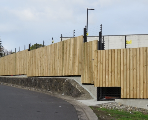 Image showing a wooden security fence surrounding an industrial building, installed by Fencerite