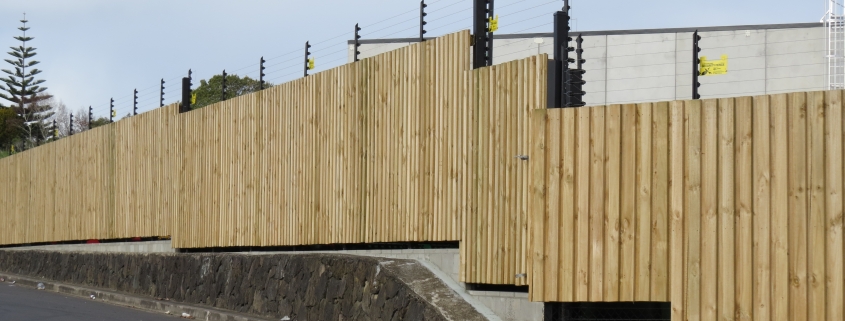 Image showing a wooden security fence surrounding an industrial building, installed by Fencerite