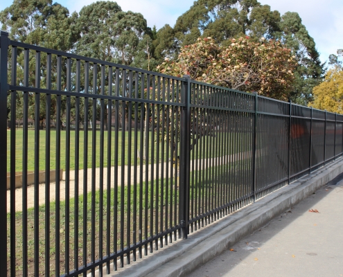 Image showing a black aluminium school fencing, bordering school playing fields, installed by Fencerite