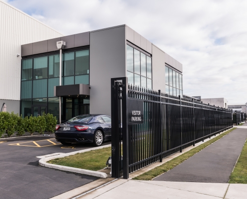 Image showing black aluminium sliding gate at the entrance of a commercial building, installed by Fencerite
