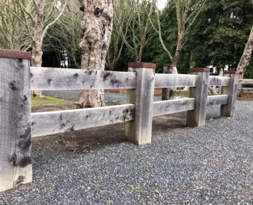 Image showing a wooden fence, bordering a rural driveway, installed by Fencerite