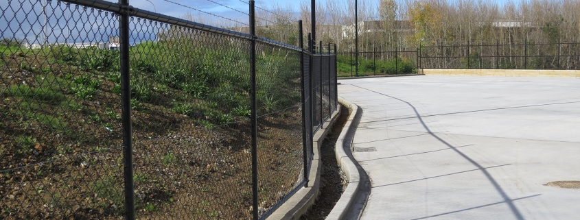 Image showing the entrance to a commercial building, with black chainlink fencing, installed by Fencerite